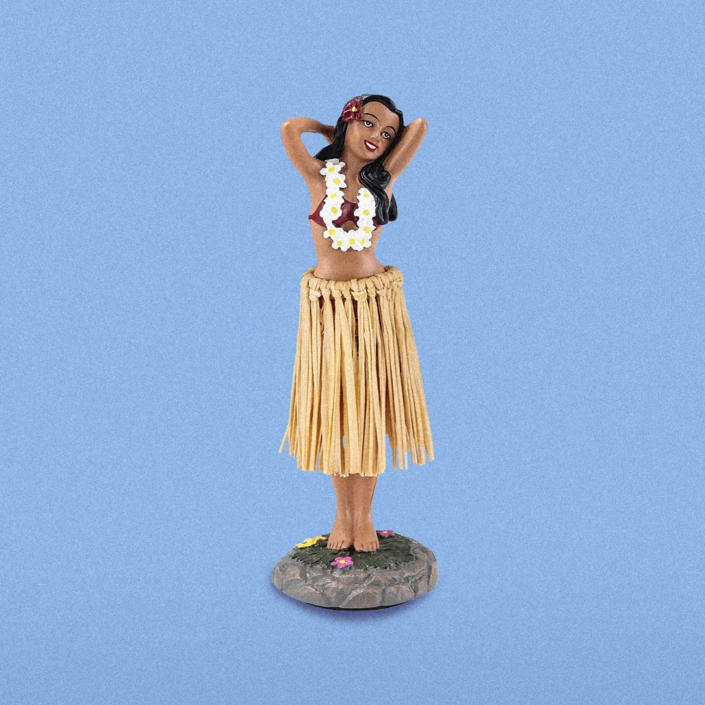 Hula bobblehead dashboard ornament on a blue background.