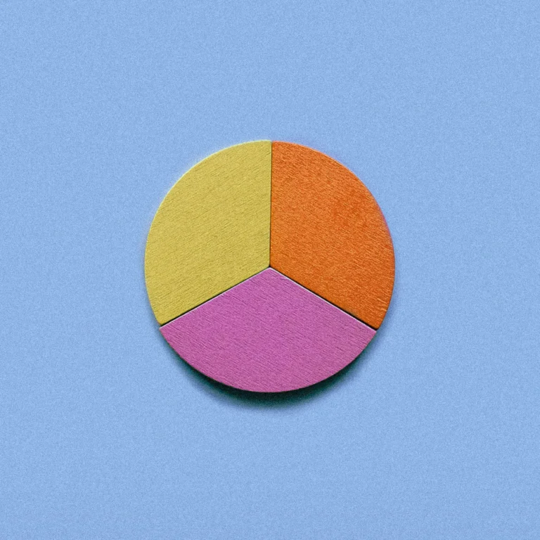 Three colored wooden pie chart blocks on a blue background.